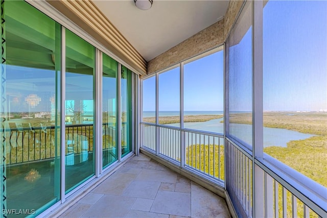 unfurnished sunroom featuring a water view