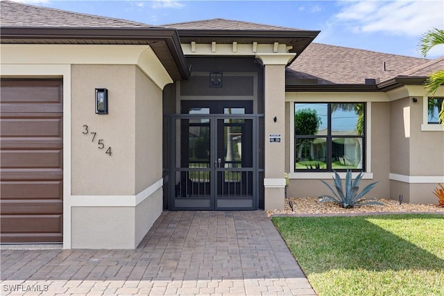 doorway to property featuring a garage and a lawn