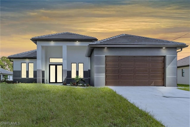 view of front of house featuring a garage and a yard