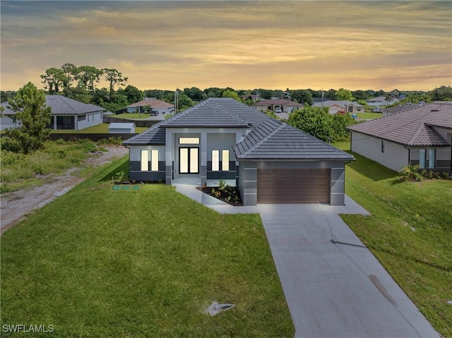 modern home featuring a garage and a yard