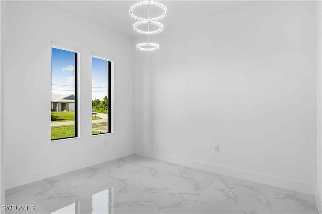 unfurnished room with a healthy amount of sunlight and an inviting chandelier