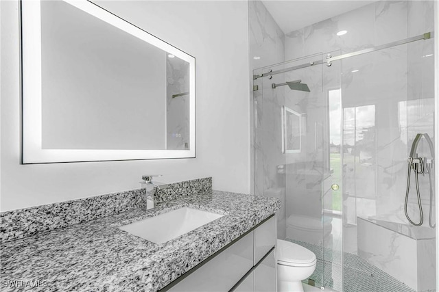 bathroom with vanity, toilet, and a shower with shower door