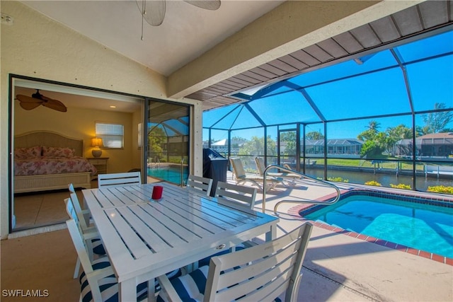 view of pool featuring a patio area, a water view, ceiling fan, and glass enclosure