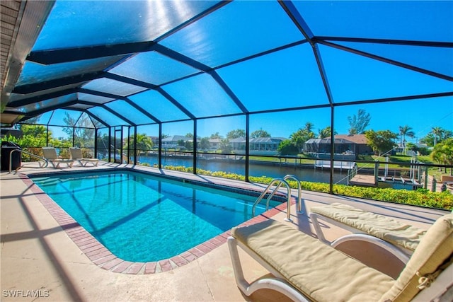 view of pool with a lanai, a patio area, and a water view