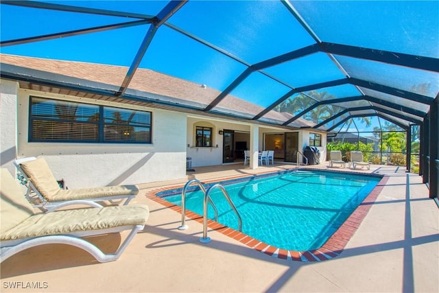 view of pool with a patio area and glass enclosure