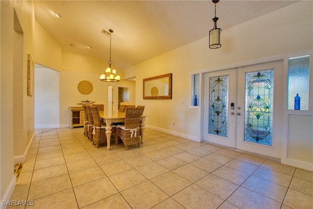 dining area with light tile patterned flooring, lofted ceiling, an inviting chandelier, and french doors