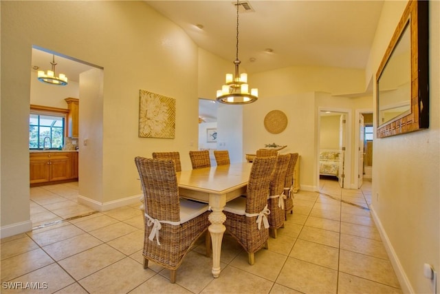 tiled dining area with sink, a chandelier, and vaulted ceiling