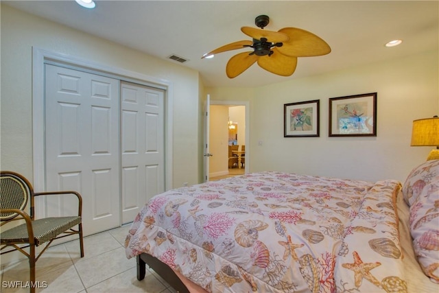 tiled bedroom with ceiling fan and a closet