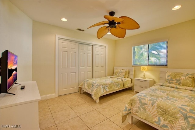 bedroom with light tile patterned flooring, ceiling fan, and a closet