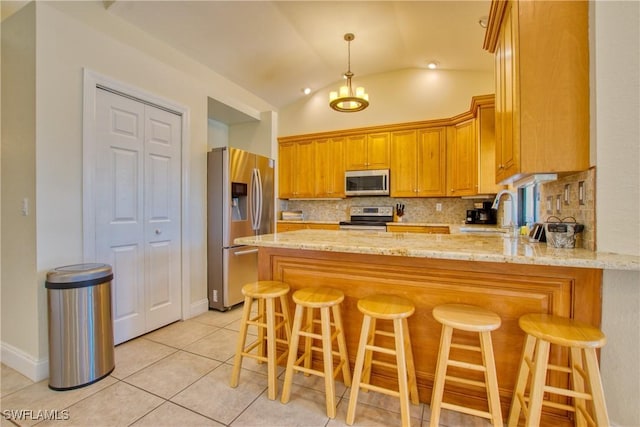 kitchen featuring sink, a breakfast bar area, stainless steel appliances, and kitchen peninsula