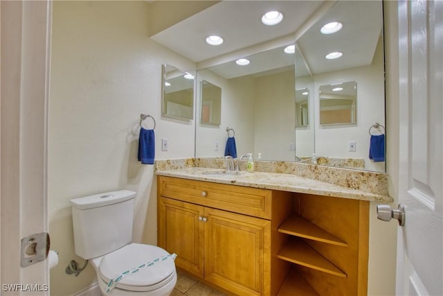 bathroom featuring vanity, tile patterned floors, and toilet