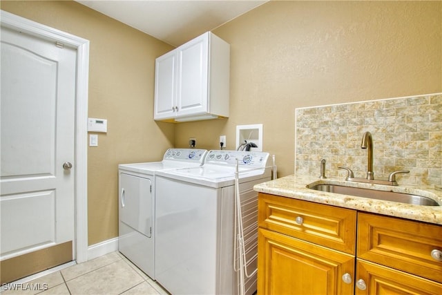 washroom featuring light tile patterned flooring, cabinets, sink, and washing machine and clothes dryer