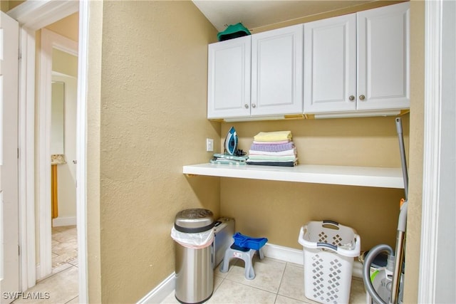 clothes washing area with light tile patterned floors