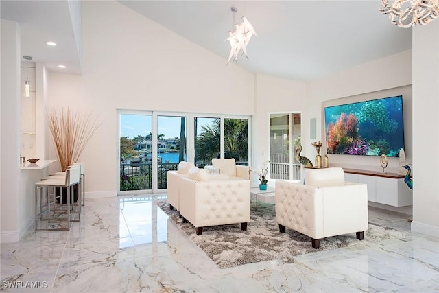 living area with baseboards, high vaulted ceiling, recessed lighting, a notable chandelier, and marble finish floor