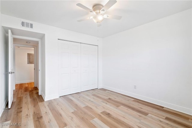 unfurnished bedroom with ceiling fan, a closet, and light wood-type flooring