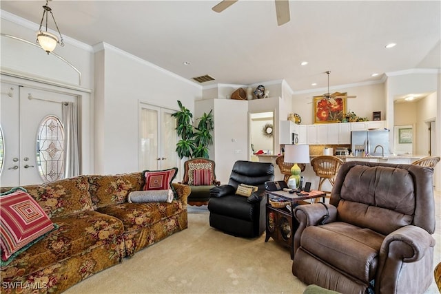 carpeted living room with french doors, ceiling fan, and crown molding