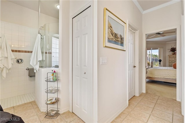 bathroom featuring a tile shower, ceiling fan, tile patterned flooring, and ornamental molding