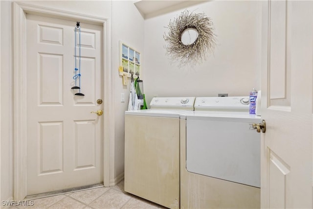 laundry area with washer and clothes dryer and light tile patterned flooring