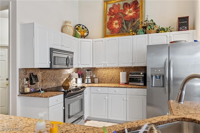 kitchen with decorative backsplash, white cabinetry, and appliances with stainless steel finishes