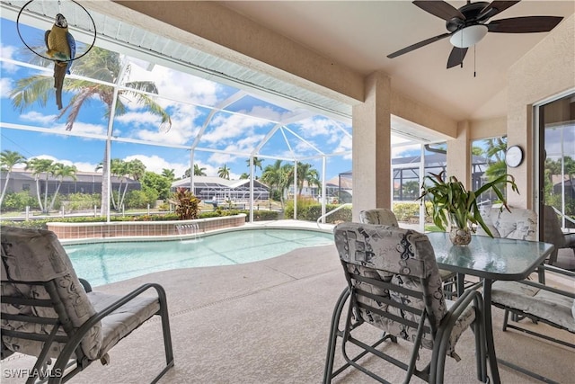 view of pool with glass enclosure, ceiling fan, and a patio area