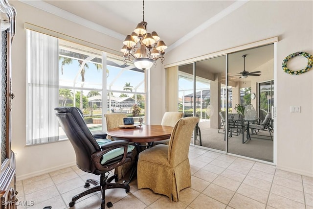 dining space featuring ceiling fan with notable chandelier, vaulted ceiling, a wealth of natural light, and light tile patterned flooring