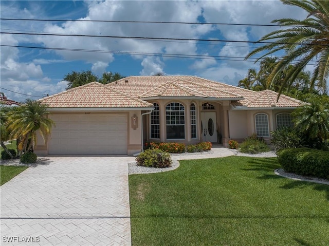 mediterranean / spanish-style house featuring a front yard and a garage