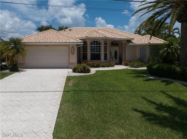 mediterranean / spanish-style house featuring a garage and a front yard