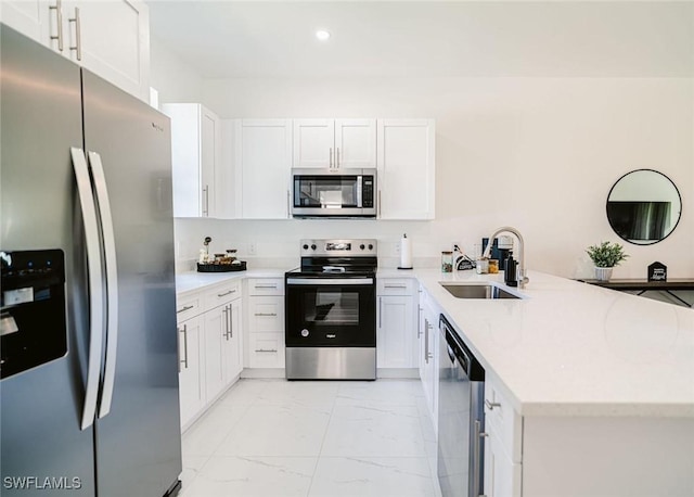 kitchen featuring sink, stainless steel appliances, kitchen peninsula, and white cabinets