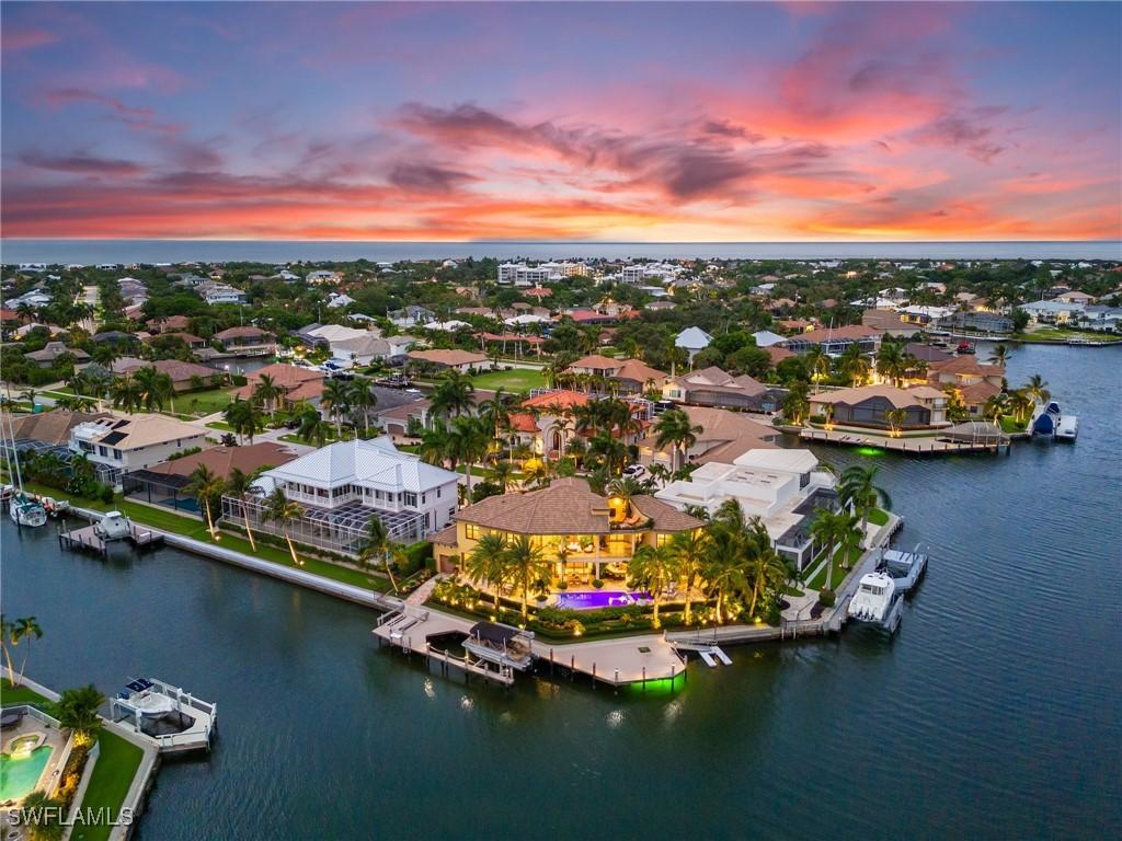 aerial view at dusk featuring a water view