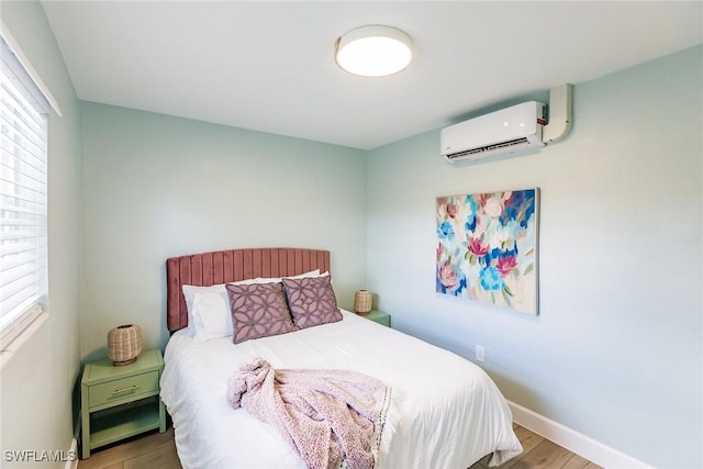 bedroom featuring hardwood / wood-style floors, an AC wall unit, and multiple windows