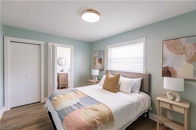 bedroom with connected bathroom, hardwood / wood-style floors, and sink