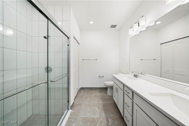 bathroom with toilet, vanity, and walk in shower