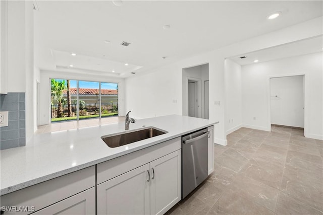 kitchen featuring light stone countertops, backsplash, white cabinets, sink, and dishwasher