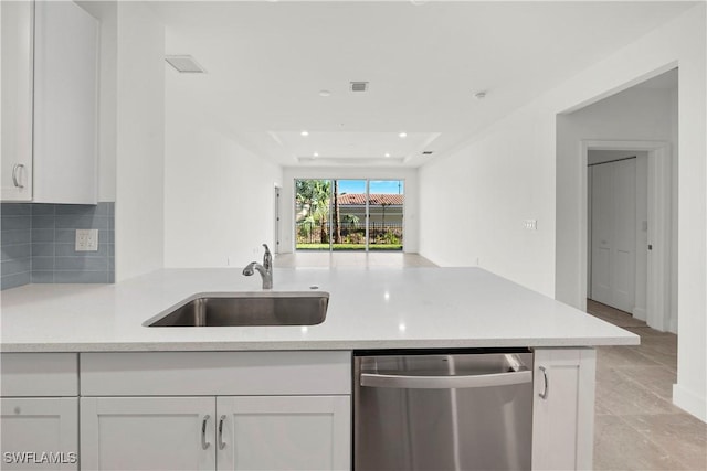 kitchen with decorative backsplash, kitchen peninsula, sink, dishwasher, and white cabinetry