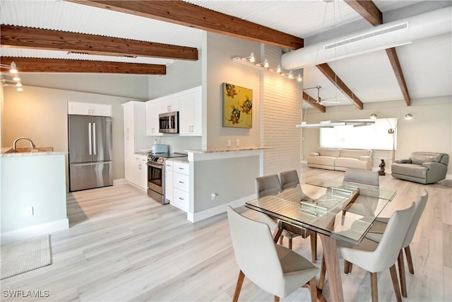 dining space featuring beam ceiling, light hardwood / wood-style flooring, and high vaulted ceiling