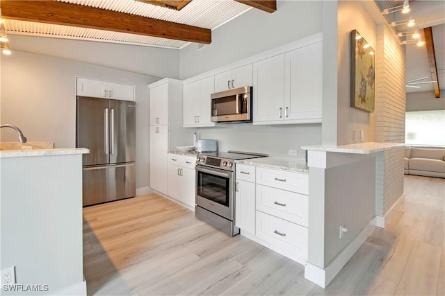 kitchen with white cabinets, light hardwood / wood-style floors, kitchen peninsula, and appliances with stainless steel finishes