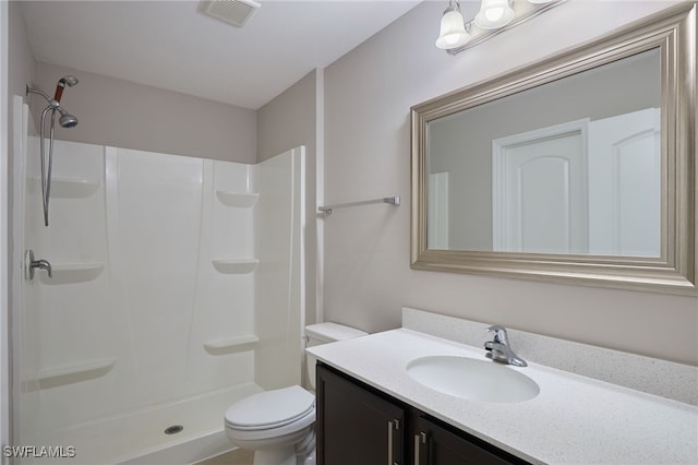 bathroom with toilet, vanity, and walk in shower