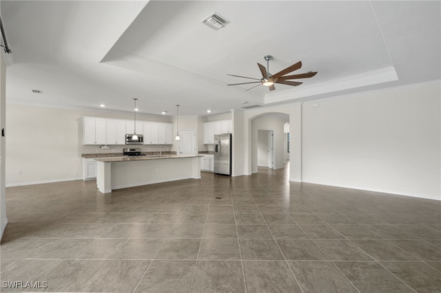 unfurnished living room with ceiling fan, a raised ceiling, ornamental molding, and light tile patterned floors