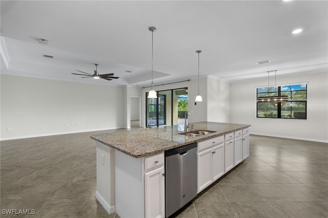 kitchen with a tray ceiling, sink, a center island with sink, dishwasher, and white cabinetry