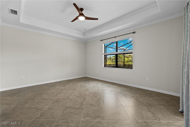 tiled empty room with a tray ceiling, ceiling fan, and crown molding