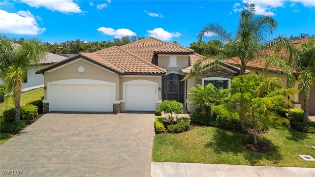 mediterranean / spanish house with a front yard and a garage