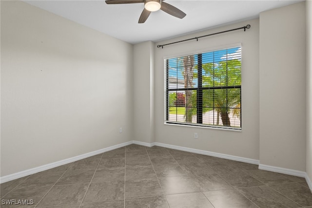 tiled empty room featuring ceiling fan