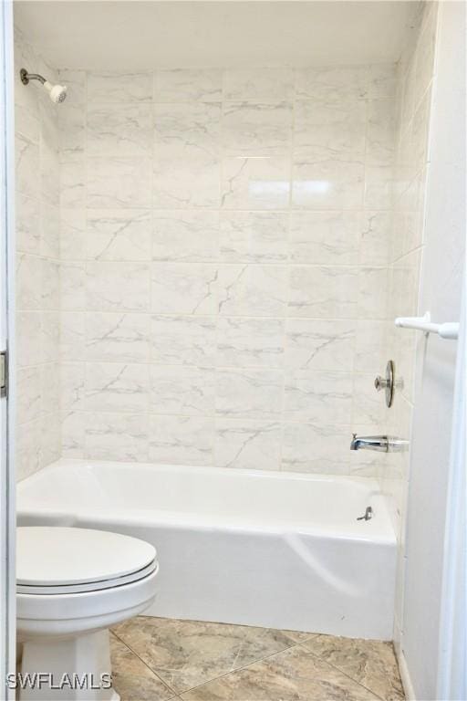 bathroom with toilet and tiled shower / bath combo