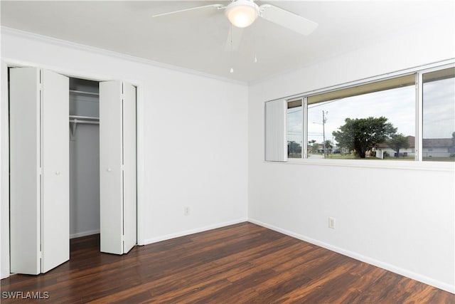 unfurnished bedroom with ceiling fan, a closet, dark hardwood / wood-style floors, and crown molding