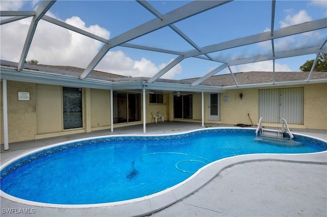 view of pool featuring glass enclosure and a patio area