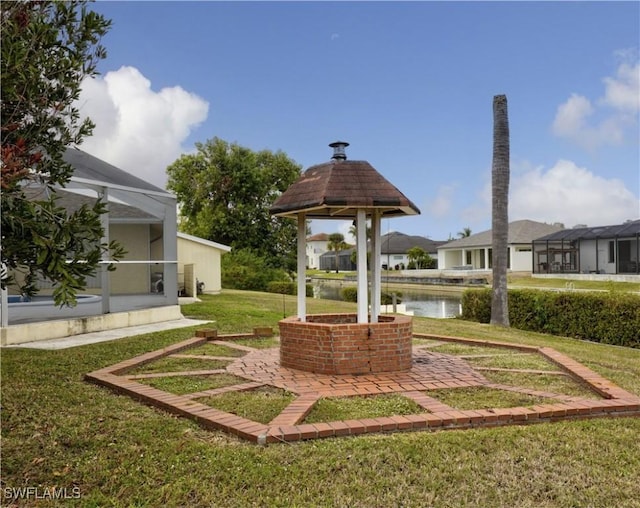 view of yard featuring a lanai and a water view