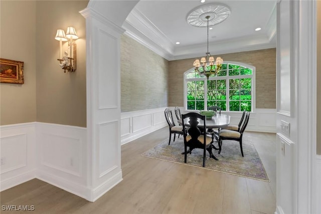 dining room with crown molding, hardwood / wood-style floors, and an inviting chandelier