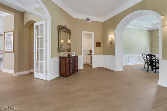 hallway with ornamental molding, light hardwood / wood-style flooring, and decorative columns