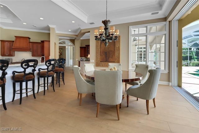 dining room with a raised ceiling, crown molding, and an inviting chandelier