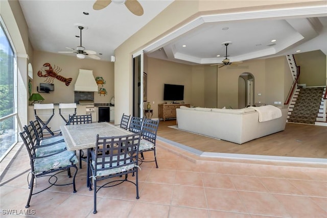 tiled dining area with a raised ceiling